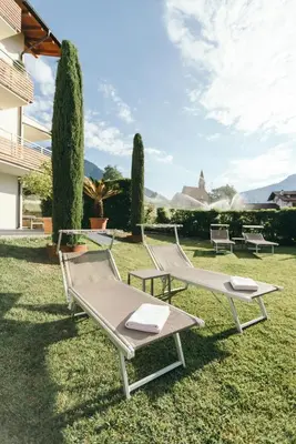 a group of chairs sitting on the grass at Apartment Ruprecht in Tirolo