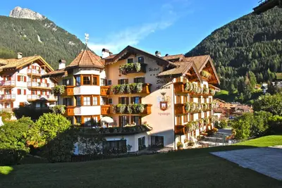 a building with balconies on the side of a mountain at Hotel Stella Alpina in Moena