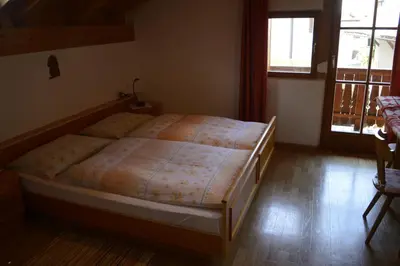 a bedroom with a bed with a wooden floor at Hof am Brunnen Mansarde in Cornaiano