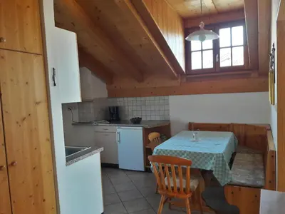 a kitchen with a table and a kitchen with a window at Hof am Brunnen Mansarde in Cornaiano