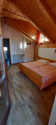 a large bed in a room with a wooden floor at Hof am Brunnen Mansarde in Cornaiano
