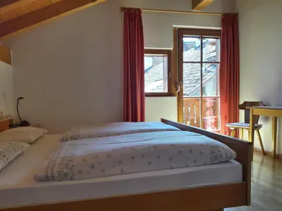 a bedroom with a bed and a large window at Hof am Brunnen Mansarde in Cornaiano