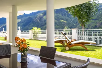 a porch with a bench and a table and chairs at Das Land-Palais - Your lovely Mountain Hideaway in Selva dei Molini