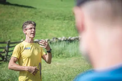 a man in a yellow shirt standing in a field at Das Land-Palais - Your lovely Mountain Hideaway in Selva dei Molini