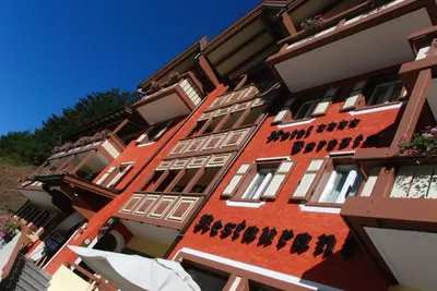 a red building with words on the side of it at Hotel Foresta in Moena
