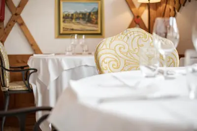 a dining room with a table and chairs with glasses at Hotel Foresta in Moena