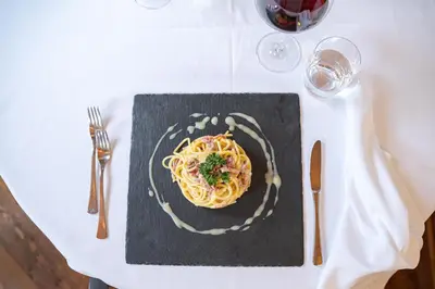 a plate of pasta on a white table at Hotel Foresta in Moena