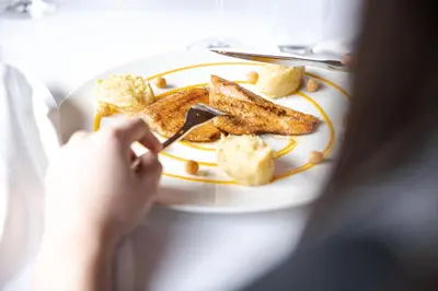 a person is eating a plate of food at Hotel Foresta in Moena