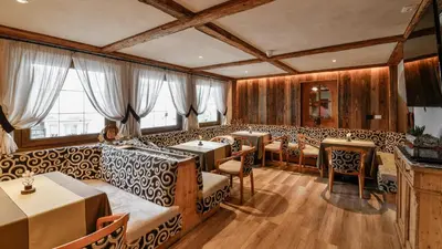 a bedroom with a bed and a desk and a table at Hotel Brunella in San Vigilio Di Marebbe