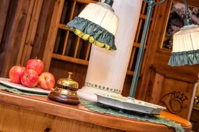 a table with two apples and a lamp on it at Hotel Brunella in San Vigilio Di Marebbe