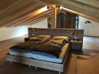 a bedroom with a large bed in a attic at Antonya Apartments in Schenna