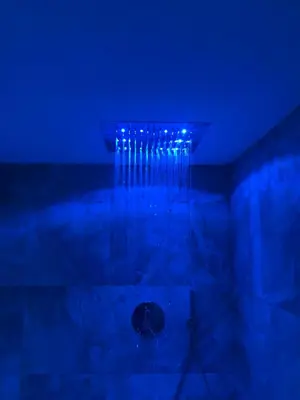 a bathroom with a shower with blue lighting at Antonya Apartments in Schenna