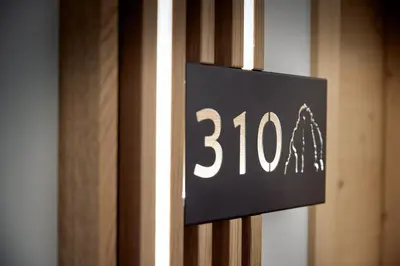 a black sign on a door with the number at Naturhotel Die Waldruhe GmbH in Chienes