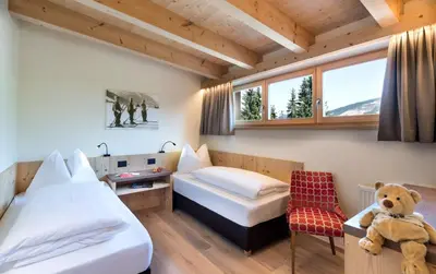 a room with two beds and a teddy bear in it at Wellness Hotel Gran Risa***S in La Villa