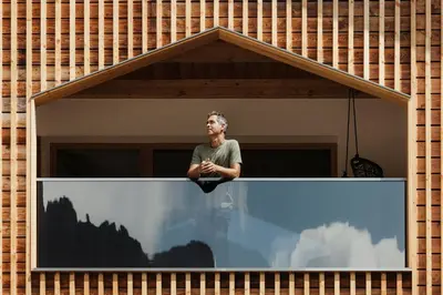 a man looking out of a window at Hotel Jägerhof in Colfosco