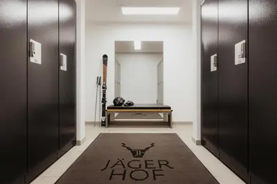 a hallway with black doors and a rug at Hotel Jägerhof in Colfosco