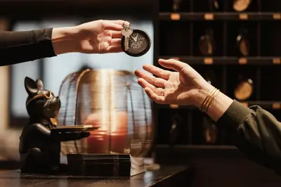 a person is handing a coin to another persons hand at Hotel Jägerhof in Colfosco