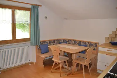 a kitchen with a table and chairs in a room at Ferienwohnung Leachwies in Schenna