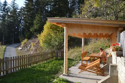 a woman sitting at a picnic table under a pavilion at Ferienwohnung Leachwies in Schenna