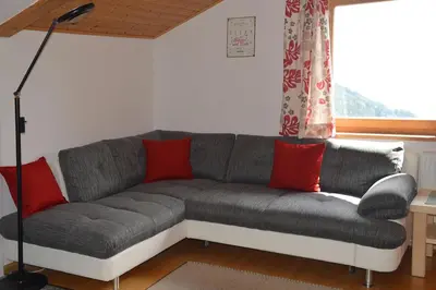 a living room with a gray couch with red pillows at Ferienwohnung Leachwies in Schenna