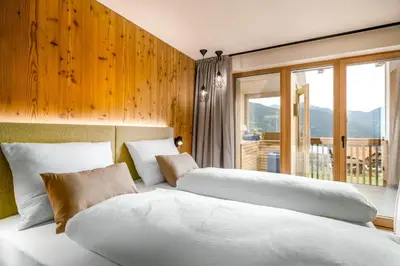 two beds sitting in a room with a window at SUMMERER - Living Nature - Apartments with private SPA in Bressanone