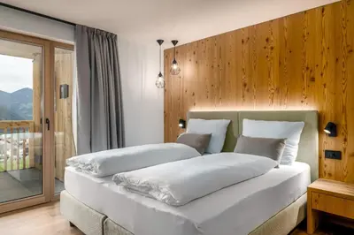 a bedroom with two beds with white sheets at SUMMERER - Living Nature - Apartments with private SPA in Bressanone