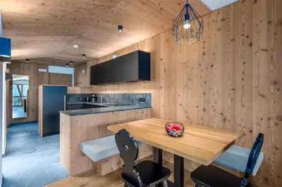a kitchen with wooden walls and a wooden table at SUMMERER - Living Nature - Apartments with private SPA in Bressanone