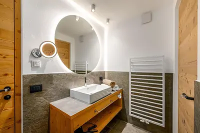 a bathroom with a sink and a mirror at SUMMERER - Living Nature - Apartments with private SPA in Bressanone