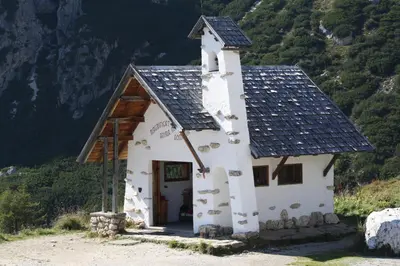 a small white building with a black roof at La Baita in Livinallongo del Col di Lana