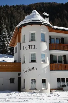a large rocky mountain with snow on it at La Baita in Livinallongo del Col di Lana