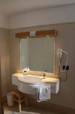 a bathroom with a door open to a room with a table at La Baita in Livinallongo del Col di Lana