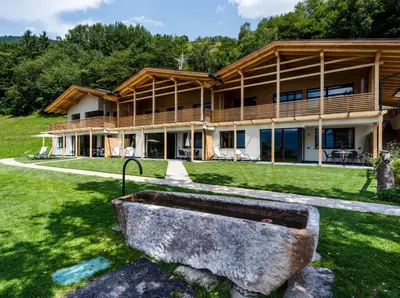 a house with a large stone tub in the yard at Apartments Grunnes in Ortisei