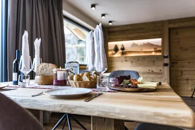 a wooden table with a plate of food on it at Apartments Grunnes in Ortisei
