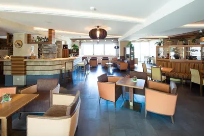 a restaurant with tables and chairs and a bar at Parc Hotel Tyrol in Castelrotto