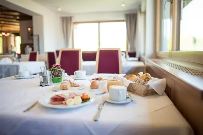 a table with plates of food and a basket of bread at Parc Hotel Tyrol in Castelrotto