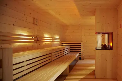 a sauna with wooden benches and a window at Hotel Der Waldhof in Vollan