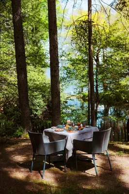 a table with two chairs and a table with food on it at Hotel Der Waldhof in Vollan