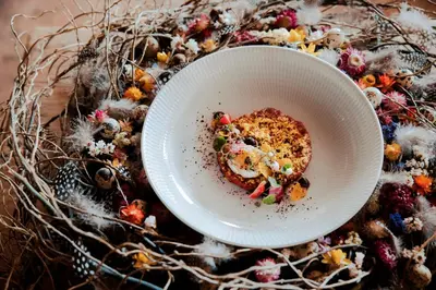 a white bowl of food on a table at Hotel Der Waldhof in Vollan