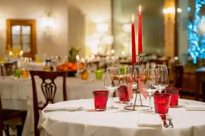 a table with wine glasses and red candles on it at Hotel Cristallino d'Ampezzo in Cortina dʼAmpezzo