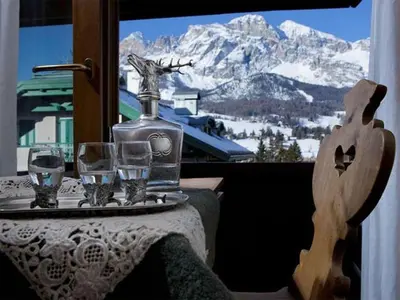 a table with wine glasses on a table with a mountain at Hotel Cristallino d'Ampezzo in Cortina dʼAmpezzo