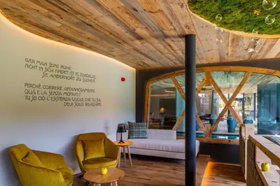 a living room with a couch and a large window at Saltria - your Alpine experience in Alpe di Siusi