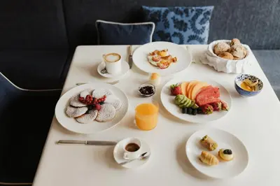 a table with plates of food and cups of coffee at Hotel Genziana in Ortisei