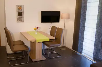 a room with a table and chairs and a television at Residence Reinhild in Nalles
