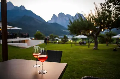 two glasses of wine sitting on a table with a view at Hotel Villa Imperina in Agordo