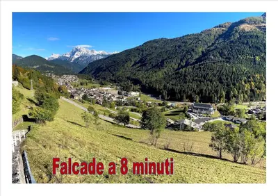 a town on a hill with mountains in the background at Piccolo Nido Falcade in Falcade