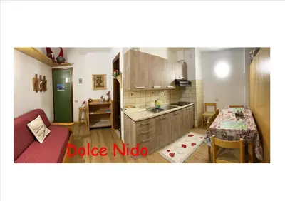 a kitchen with a table and a dining room at Piccolo Nido Falcade in Falcade