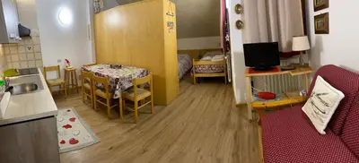a small room with a kitchen and a dining room at Piccolo Nido Falcade in Falcade