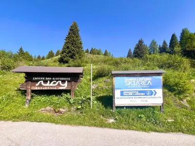 two signs sitting on the side of a road at Piccolo Nido Falcade in Falcade