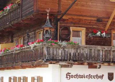 a wooden house with flowers on the balcony at Hochwieserhof in Monguelfo
