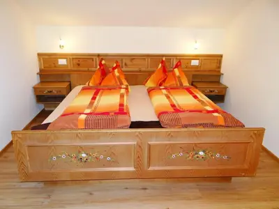 a bedroom with two beds with orange and brown pillows at Hochwieserhof in Monguelfo